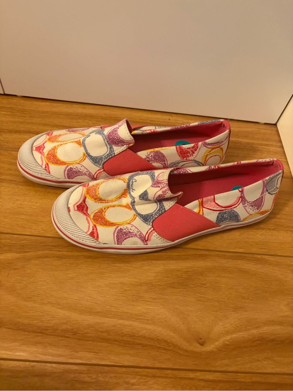 Coach Women's Slip-On Sneakers in White with Pink, Yellow & Blue Logo Print